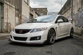 Honda Civic Type R EP3 blanche garée de trois quarts avant dans une ruelle industrielle urbaine