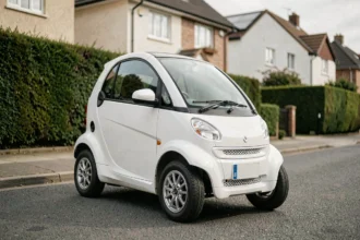 Petite voiture sans permis blanche garée dans une rue résidentielle calme, vue de trois quarts avant